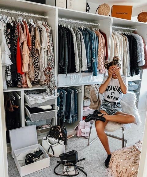 Chica frente a un closet repleto de ropa