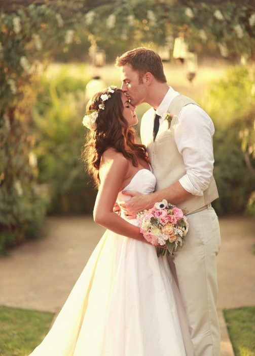 pareja de novios el día de su boda posando para una fotografía 