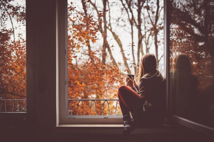 chica pensativa en una ventana 