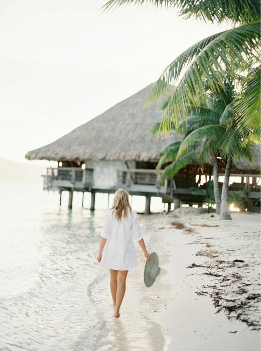 Chica caminando a la orilla de la playa 