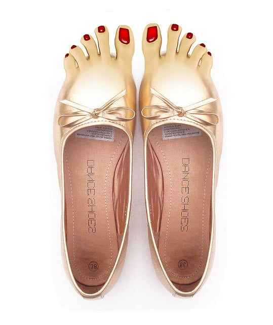zapatos dorados en la punta tienen unos dedos con uñas de color rojo 