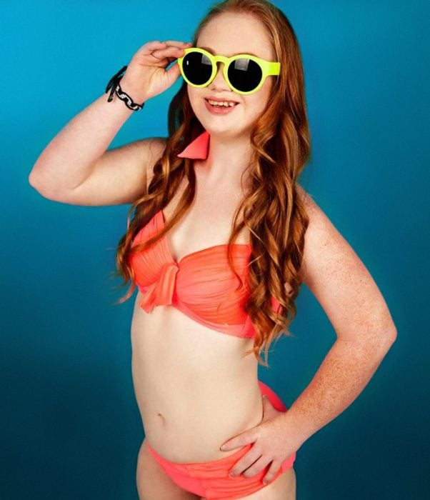 chica con síndrome de down en bikini y con lentes posando para una fotografía 