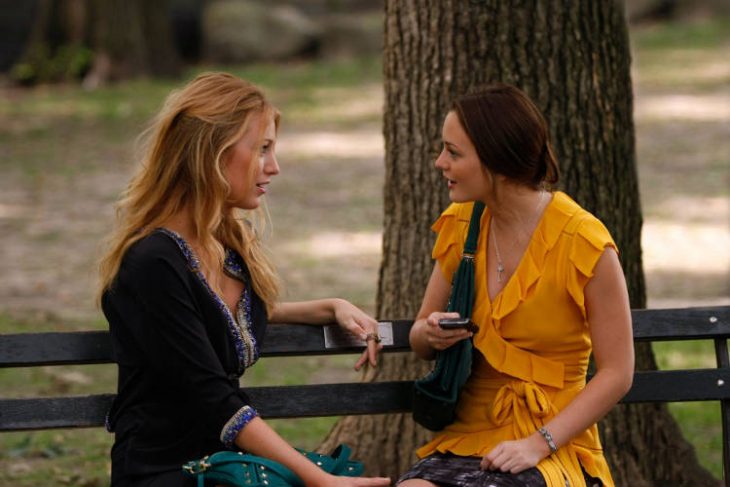 chicas conversando sentadas en la banca de un parque 