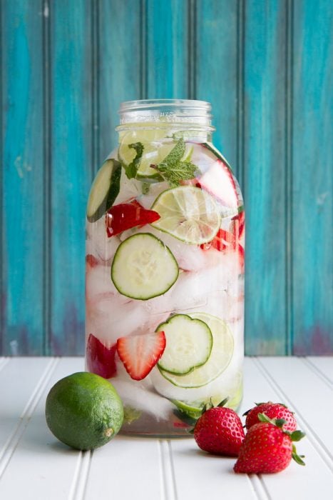 vaso con agua de frutas de limón y fresa con hielos 