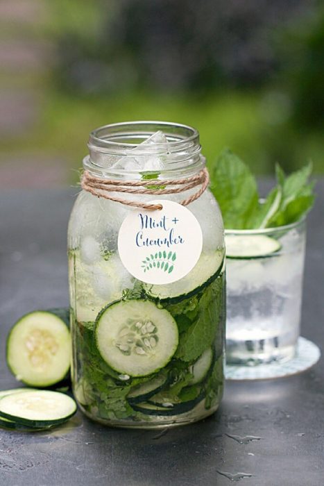 vaso con agua de pepino y rodajas de pepino y menta 