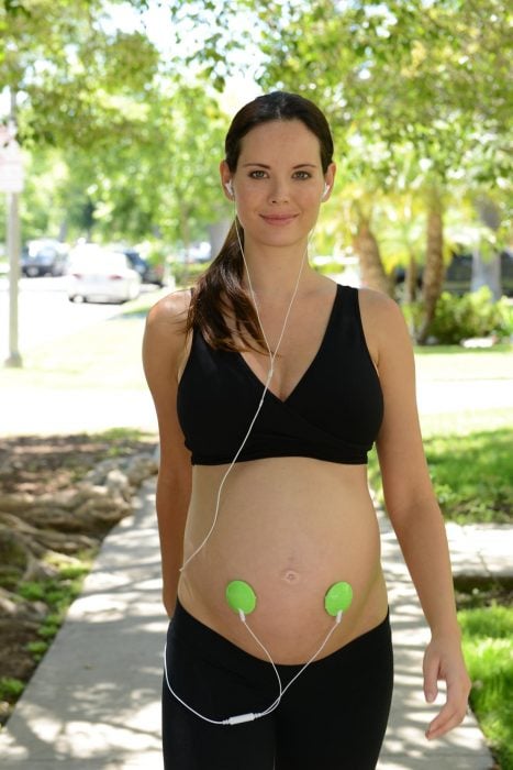 mujer embarazada escuchando música mientras camina 