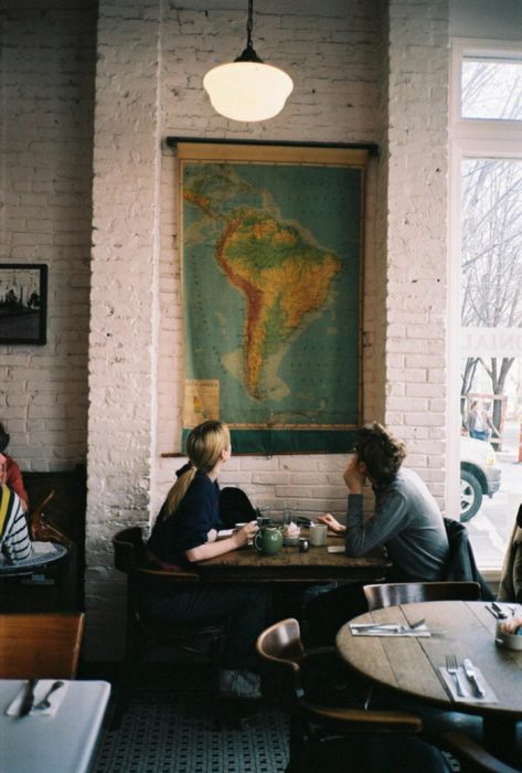 pareja sentada en un restaurante viendo un mapa 