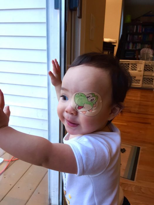 niña con un parche en el ojo en forma de dinosaurio 