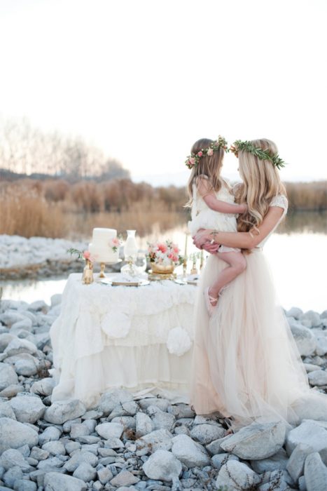 madre e hija junto a la playa con un pastel en una mesa 