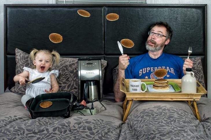 niña y su papá comiendo hotcakes en la cama 