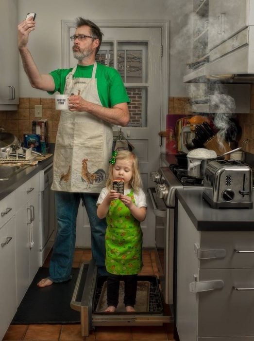 hombre y niña tomando una selfie en la cocina 