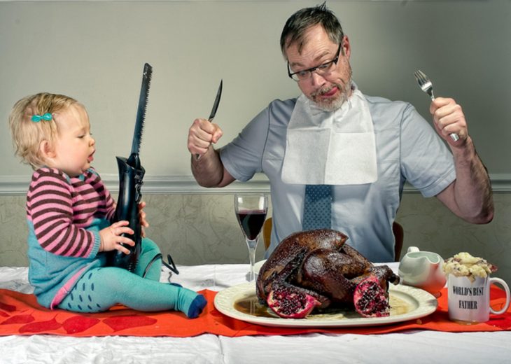 hombre y niña cortando un pavo para la cena 