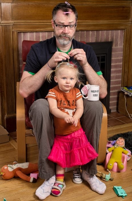 hombre peinando a una niña con trenzas 