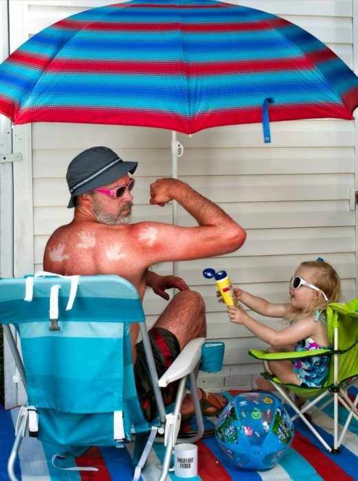 hombre lleno de bloqueador solar aplicado por su hija 