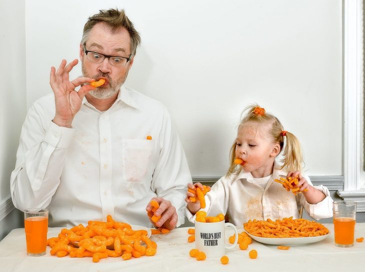 hombre y su hija comiendo chetos 