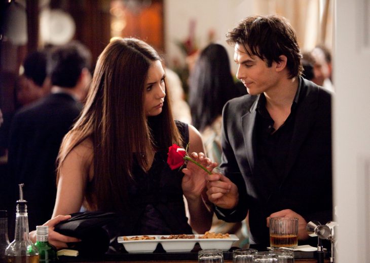 Escena de la serie the vampire diares elena y damon hablando en una fiesta 