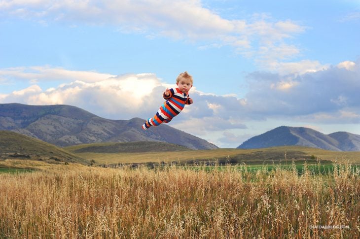 niño volando sobre un campo 