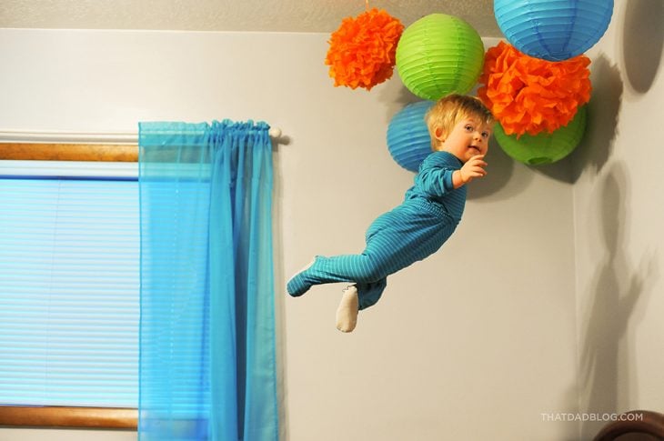 niño que simula volar en su habitación 