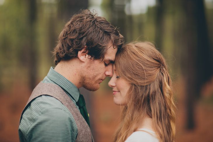 pareja de novios abrazados mirándose frente a frente 