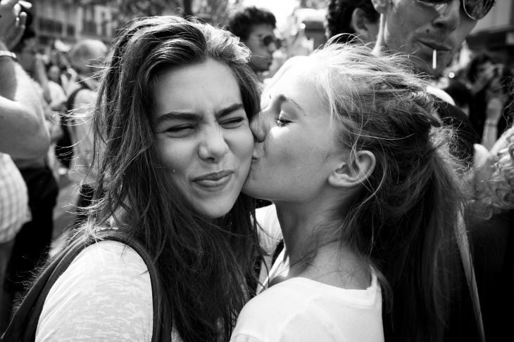 Chicas dándose un beso en el cachete 