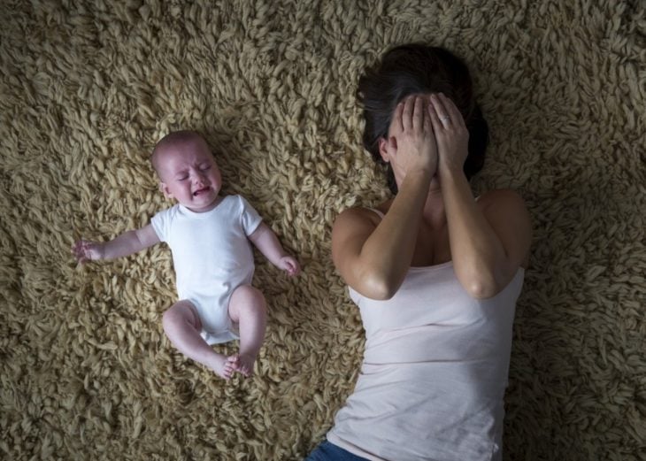 mujer llorando junto a su bebé