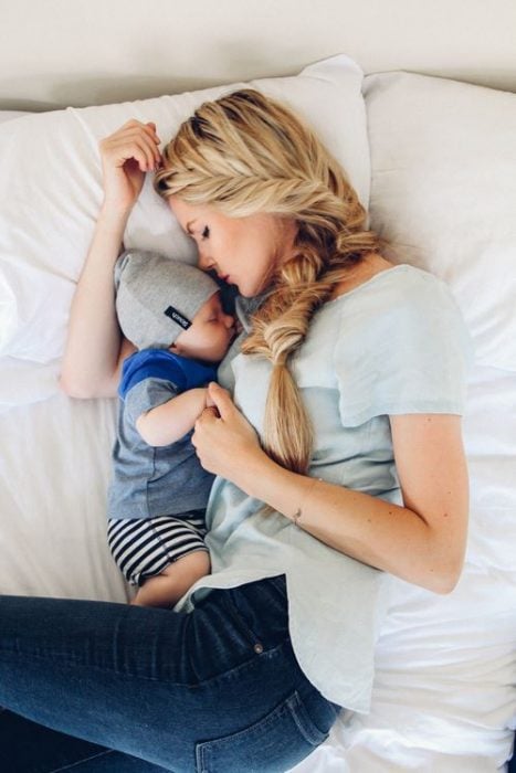 mujer dormida frente a su bebé 