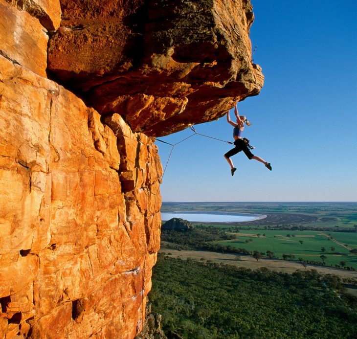 chica escalando una montaña 