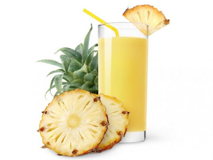 jugo de piña en un vaso con rodajas de piña 