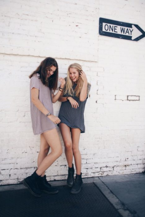 chicas en recargadas en una pared sonriendo 