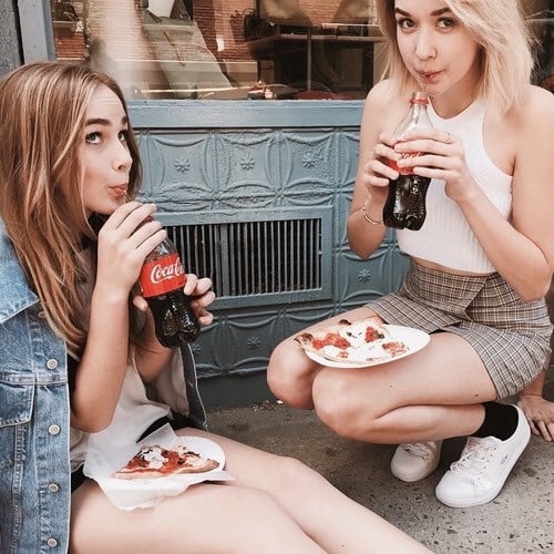 chicas comiendo pizza y tomando refresco 