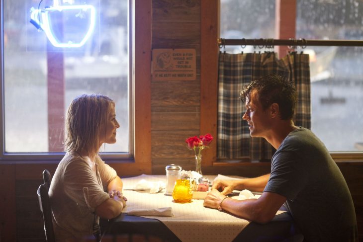 Pareja de novios sentados en un restaurante hablando 