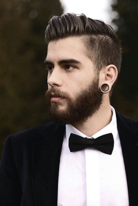 Hombre con traje, barba, expansiones y corte de cabello dapper 