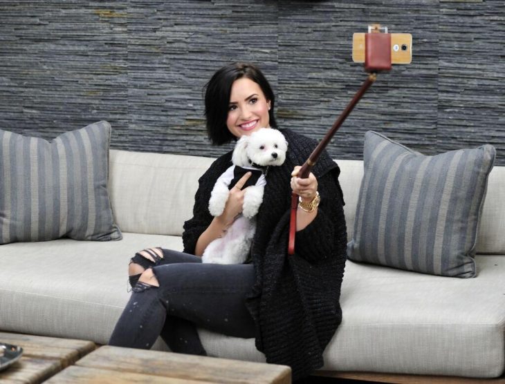 Demi Lovato con su perro tomándose una foto 