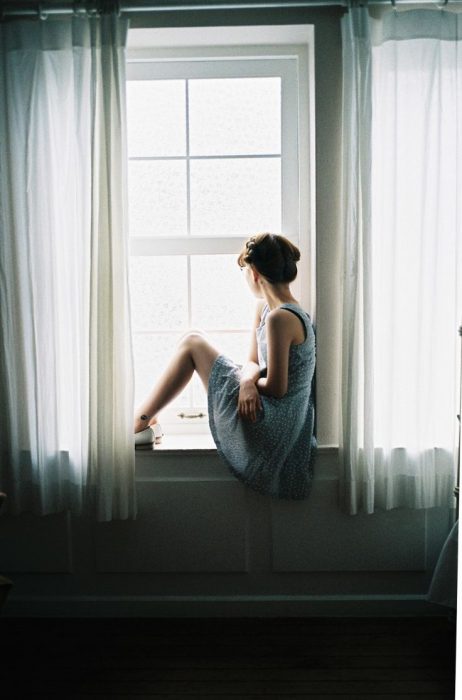 chica observando por la ventana 