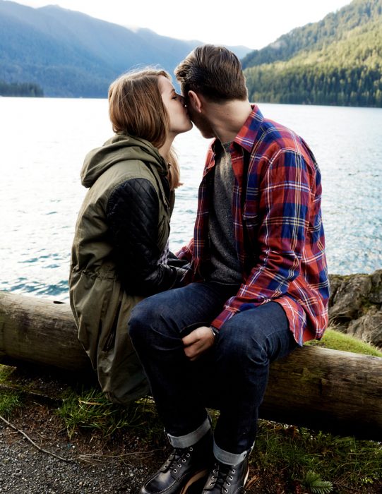 Pareja de novios sentados a la orilla de un río 