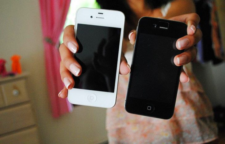 Chica con dos iphones en las manos 