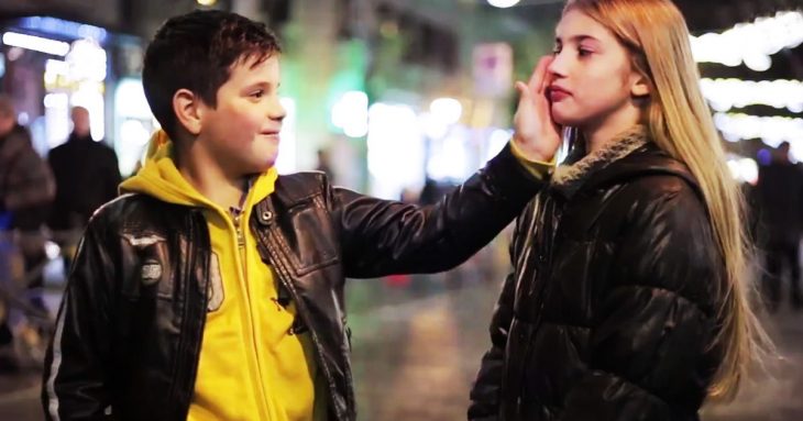 Niño con su mano puesta en la mejilla de una niña