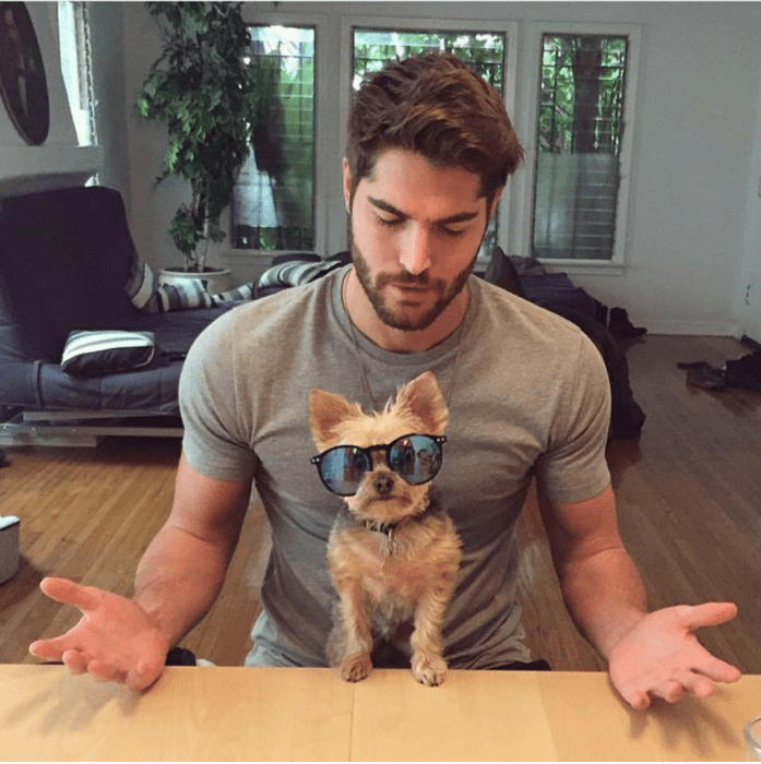 chico con un cachorro en sus piernas que esta usando unos lentes 