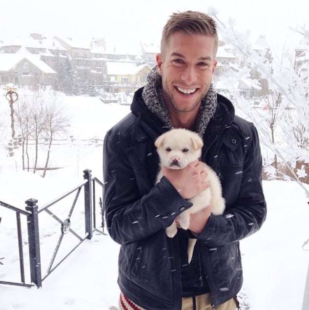 chico en medio de la nieve sosteniendo a un perro labrador 