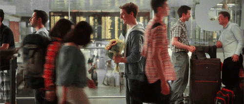 chico parado en un aeropuerto esperando a una chica 