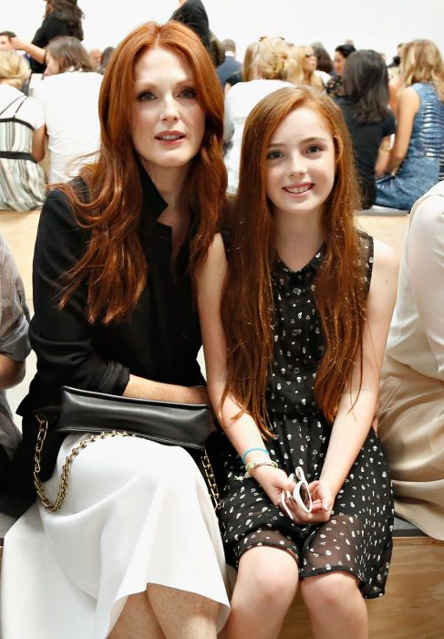 Actriz de hollywood sentada junto a su hija que tiene el cabello rojo al igual que ella 