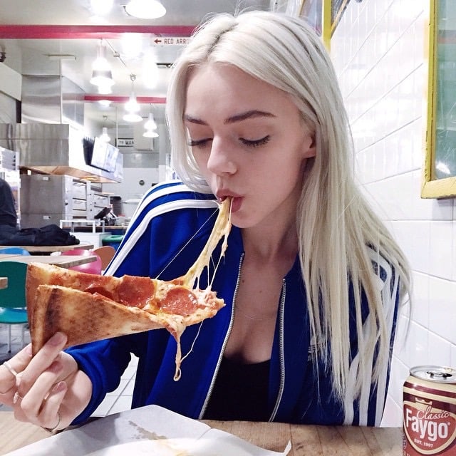 Chica comiendo un trozo de pizza 