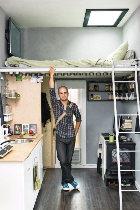 hombre que está en una habitación con cocina sala y dormitorio en la parte superior 