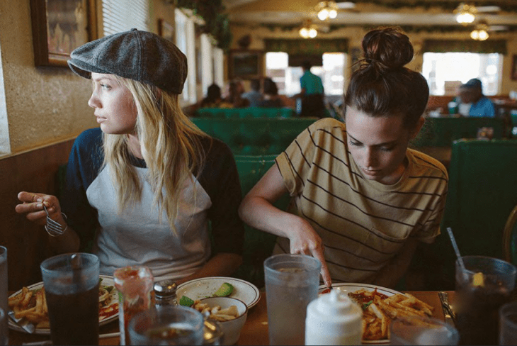 chicas comiendo papas fritas en la mesa 