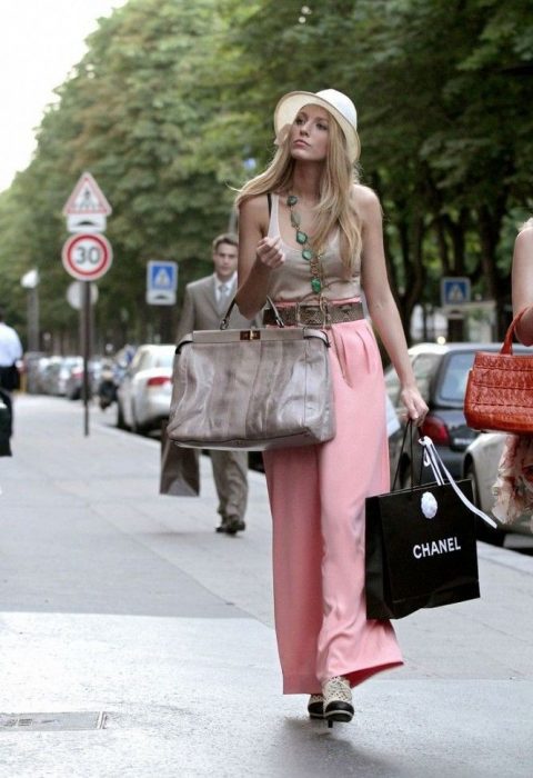 chica caminando por la calle con bolsas en las manos 