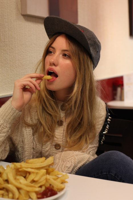 chica comiendo papas a la francesa 