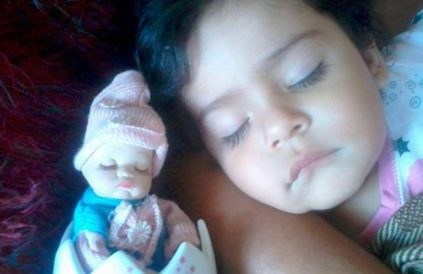 bebe dormida junto a su muñeca que es casi como ella 
