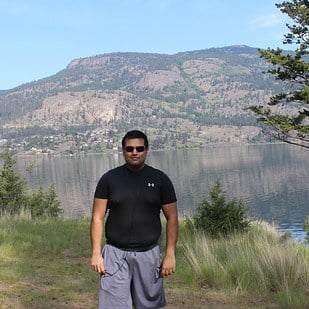 hombre parado en medio de un lago tomándose una fotografía 