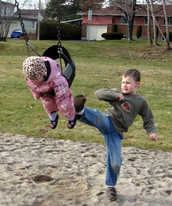 niño pequeño pateando el columpio de su hermana 