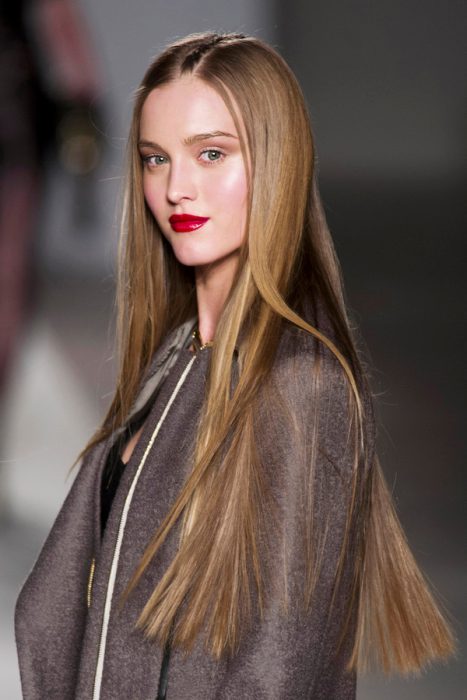 Chica con el cabello liso desfilando en una pasarela de modas 